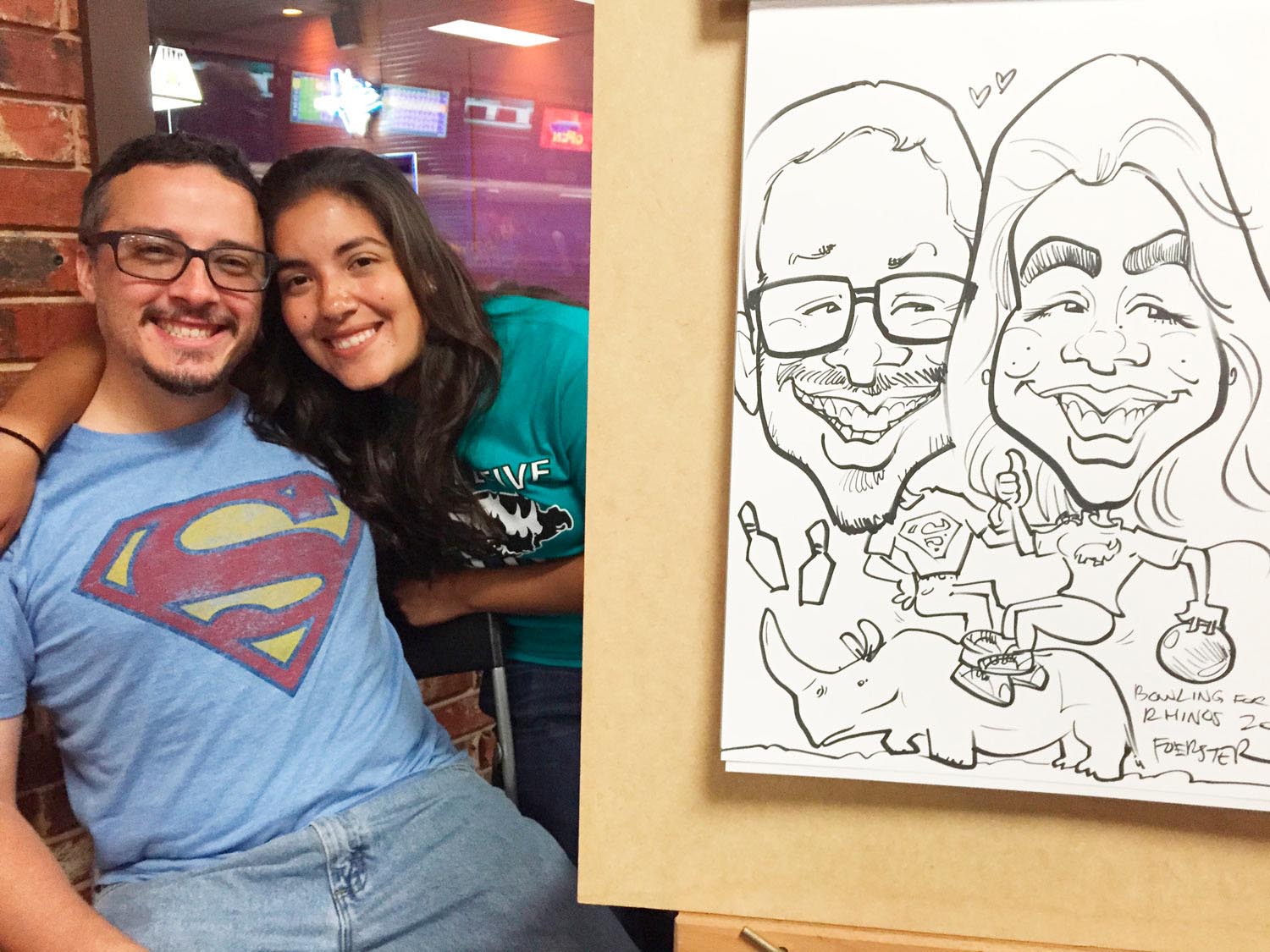 Couple stand behind their caricature